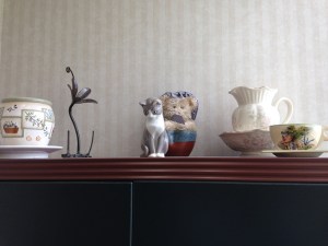 In a back corner I have a large armoire-style hutch...these adorn the top, including a tartwarmer and a metal wrought thread cone holder that's pretty enough to stand alone. The grey kitty is a twin of my little Pansy Sweetpea at home